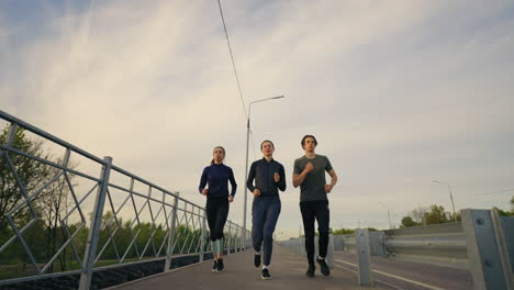 joggers-in-morning-three-persons-are-running-outdoors-along-road-frontal-view-sporty-lifestyle